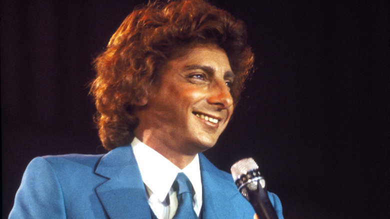 Barry Manilow tenant un micro tout en portant un costume bleu