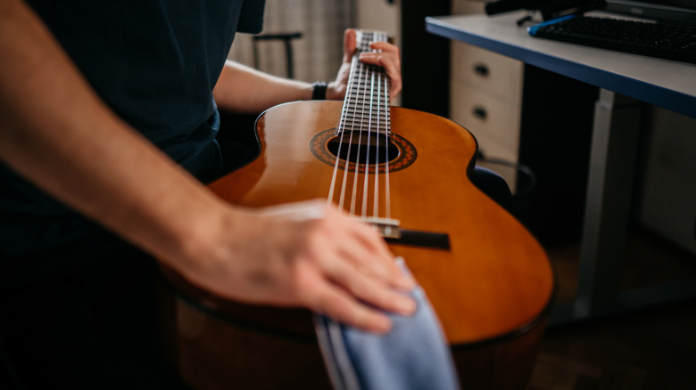 Homme essuyant la guitare