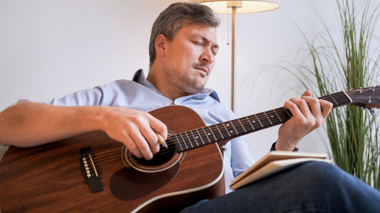 Guy pratiquant la guitare acoustique