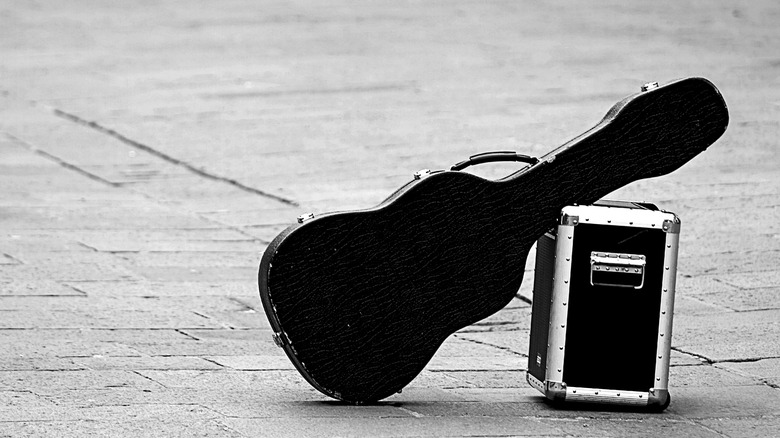 Guitare à étui rigide appuyée contre la boîte