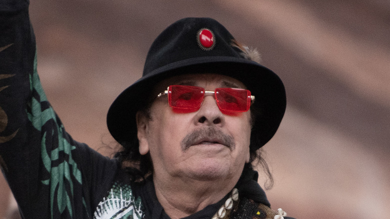 Carlos Santana sur scène regardant la foule avec le bras levé