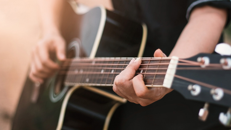 Personne jouant de la guitare acoustique