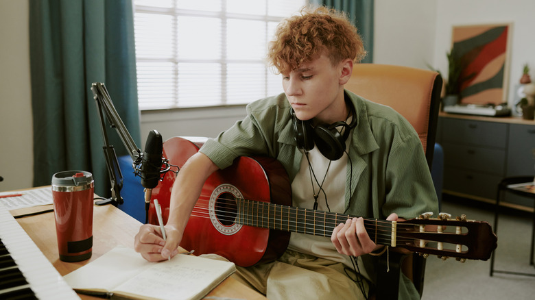 Jeune homme étudiant la guitare