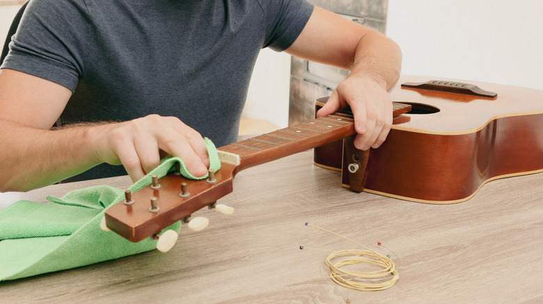Nettoyage minutieux de la guitare sans cordes avec un chiffon