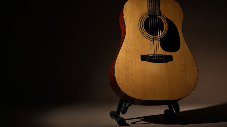 Une guitare acoustique sur un stand