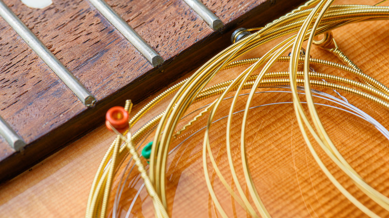 Cordes de guitare de rechange près d'un manche de guitare