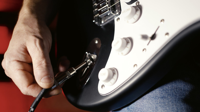 Un câble branché sur une guitare électrique
