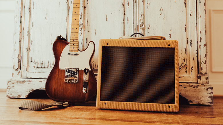 Un ampli de guitare à côté d'une guitare