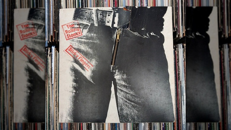 Les Rolling Stones "Doigts collants" LP avec fermeture éclair, posé au-dessus d'autres disques