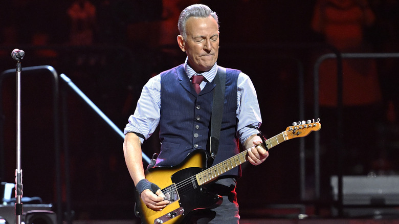 Bruce Springsteen sur scène avec une guitare.