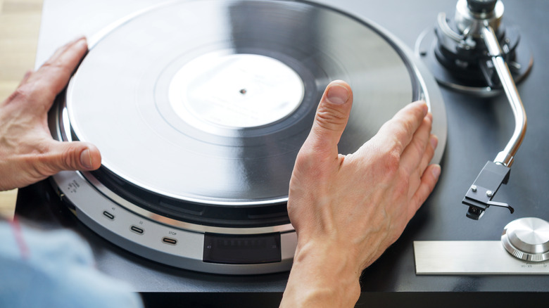 mains plaçant un disque sur une platine